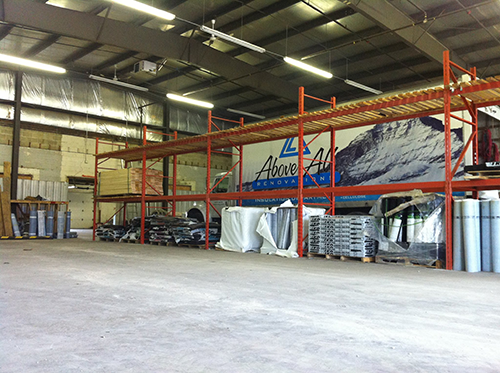 Warehouse interior with roofing supplies and truck.
