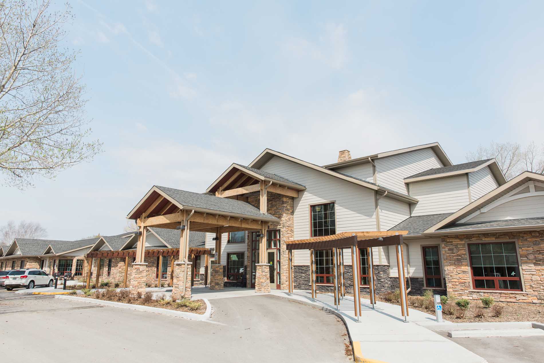 A large, modern building with a covered entrance, stone and wood accents, and a welcoming feel.