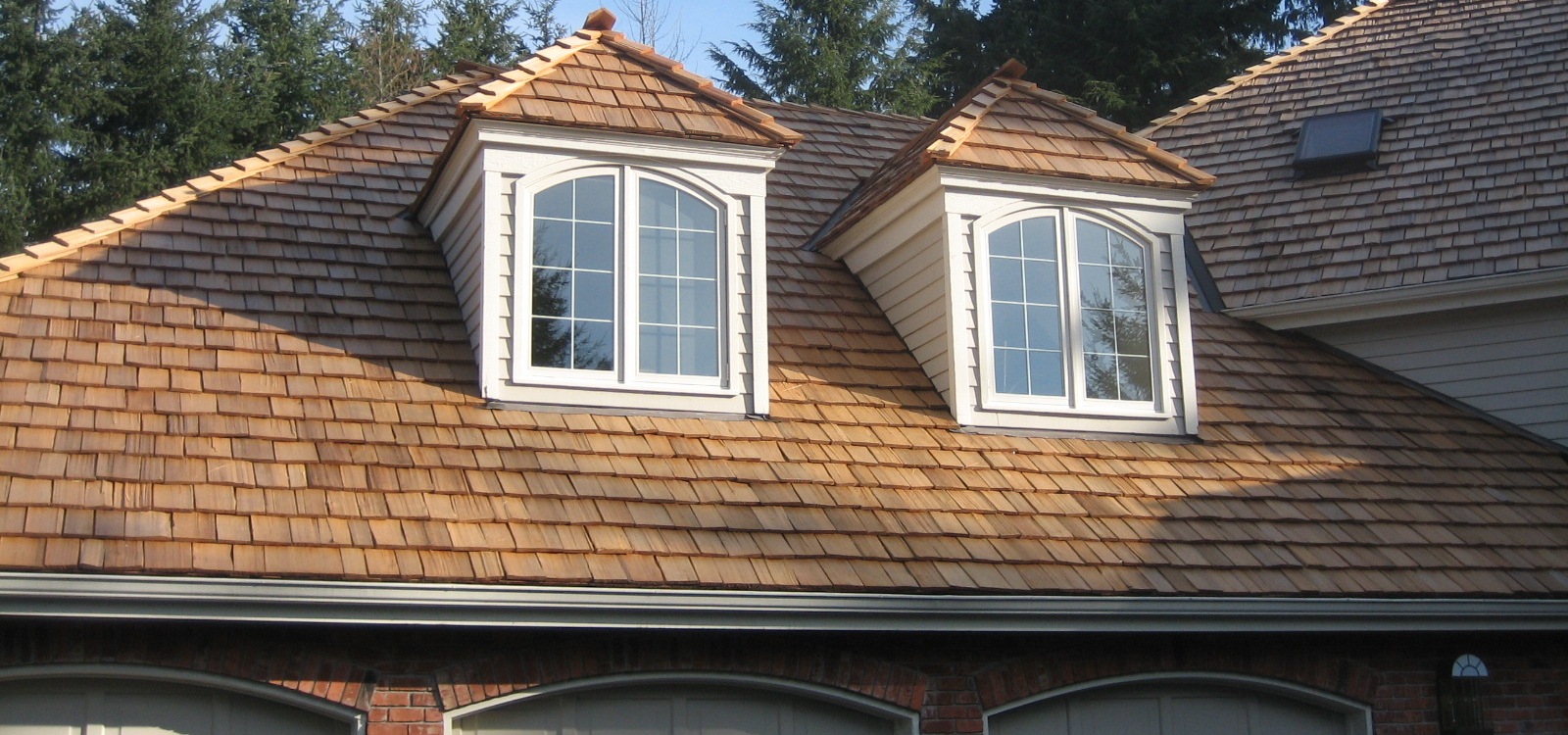 Cedar shake roof with two dormers.